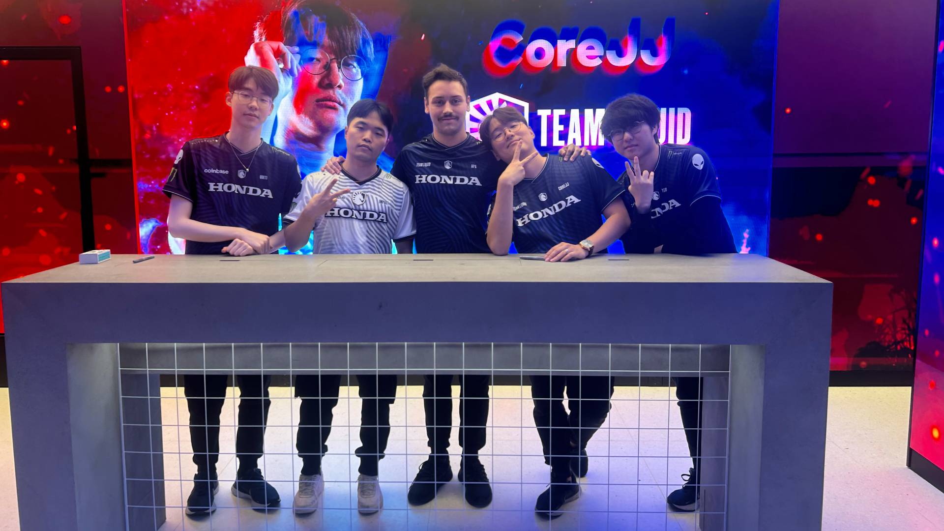 An image of Team Liquid's League of Legends squad standing at a table 